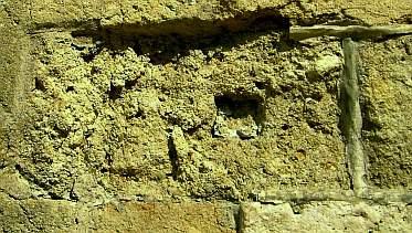Die durch Zementmörtel gestörte Entfeuchtung der Fassade verursacht tiefgreifende Schädigung der Natursteine: Abblättern, Rißbildung, Hohllagen, Schollenbildung